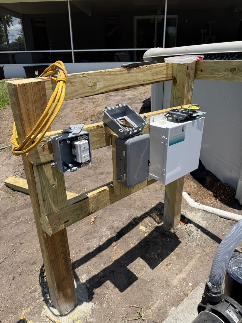 Outdoor equipment stand with weatherproof outlets and a timer wired next to a pool