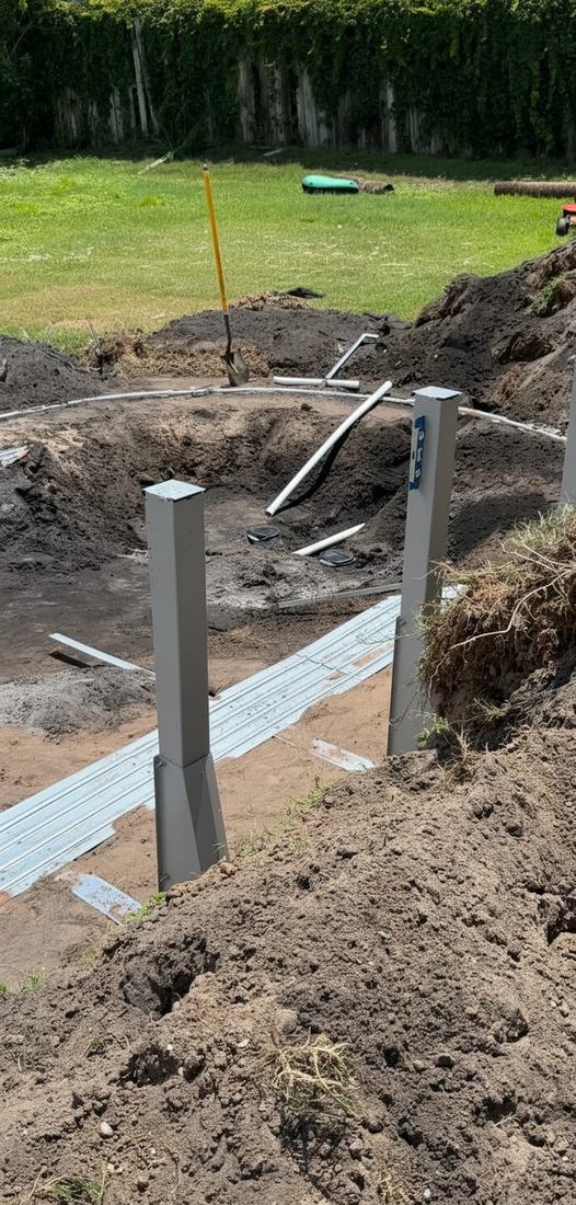 Plumbing lines run to the pool base with the bottom track and wall uprights set